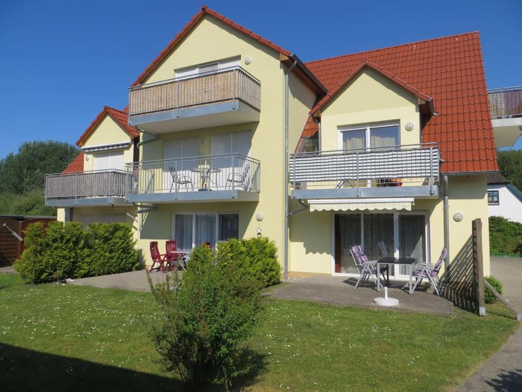 a house with two balconies and a yard with chairs at Zum Strandkorb in Zingst