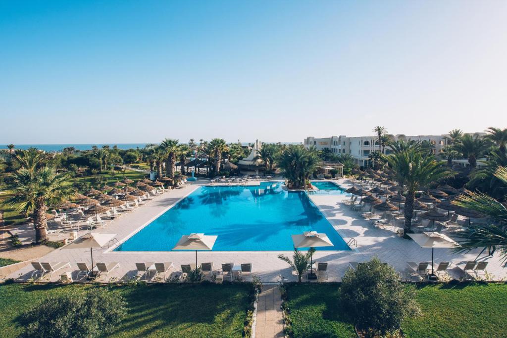 an overhead view of a swimming pool with chairs and palm trees at Iberostar Waves Mehari Djerba in Taguermess