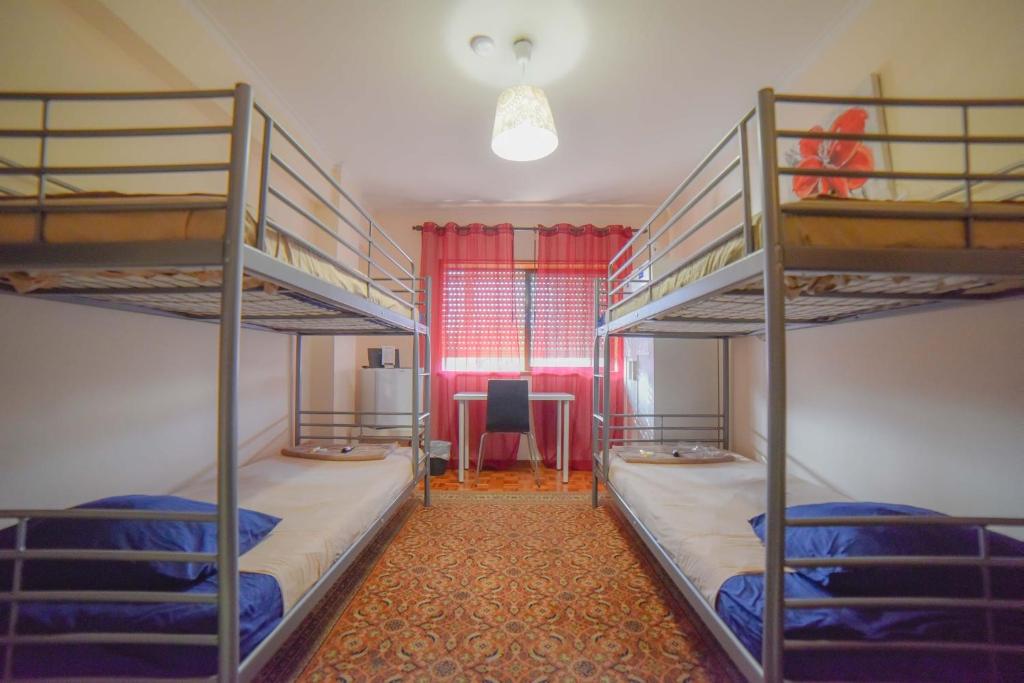 Zimmer mit 2 Etagenbetten und einem Schreibtisch in der Unterkunft Quarto com 4 camas (Beliches+ 1 Sofá-cama) in Porto