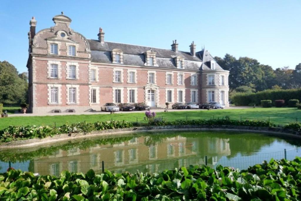 una casa grande con un estanque frente a ella en Château de Behen, en Béhen