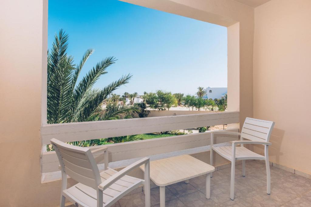 a balcony with a table and chairs and a view of the beach at Iberostar Waves Mehari Djerba in Taguermess