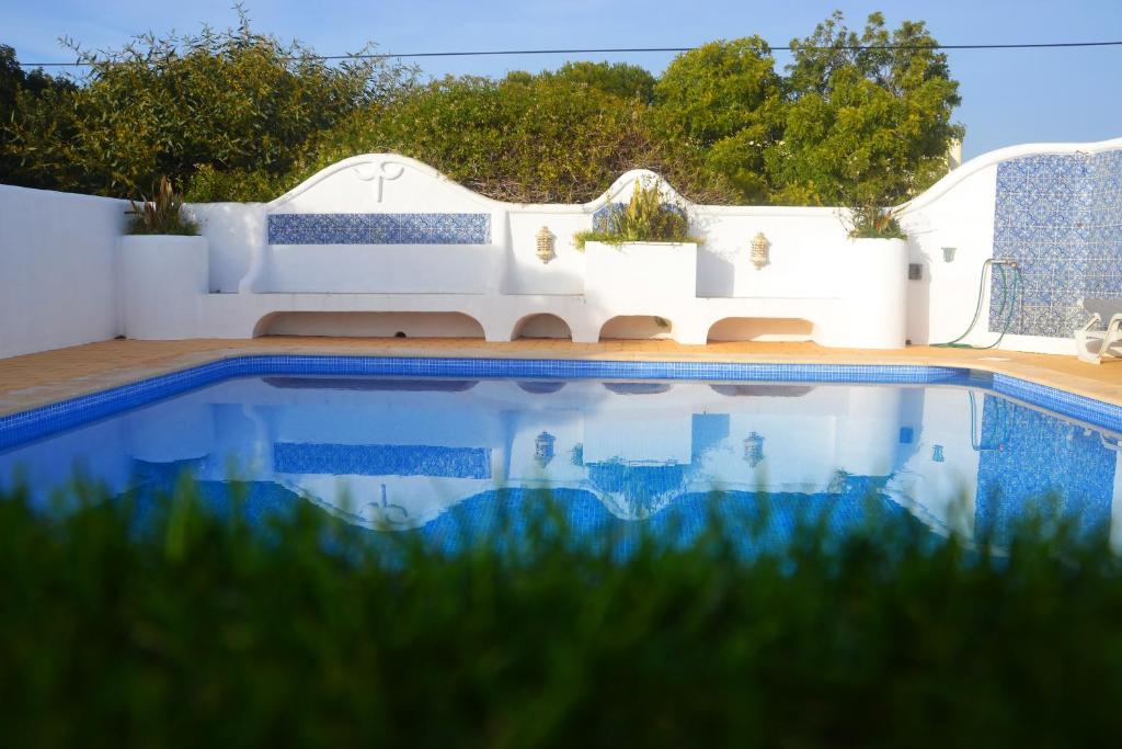 a swimming pool in front of a white house at Villa on the Beach by GalanteVasques in Carvoeiro