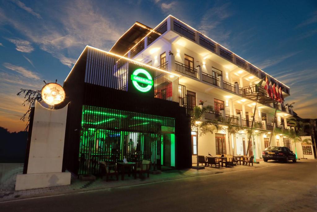 a building with a green sign on the side of it at Asian Grand Hotel in Negombo
