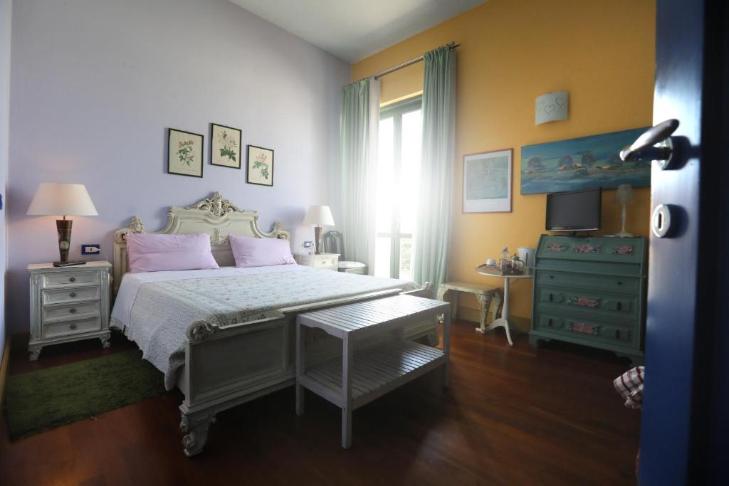 una camera da letto con un letto con cuscini rosa e una finestra di IL NIDO AL LAGO a Gavirate