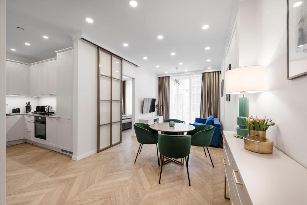 a kitchen and living room with a table and chairs at Aula apartments in Vilnius