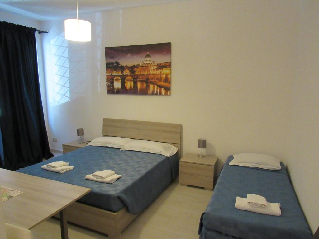 ローマにあるPIANETA ROMA 39のベッドルーム1室(ベッド2台、テーブル、タオル付)