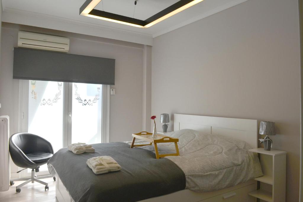 une chambre avec un lit, une chaise et une fenêtre dans l'établissement Chic & Cozy Apartment, à Thessalonique