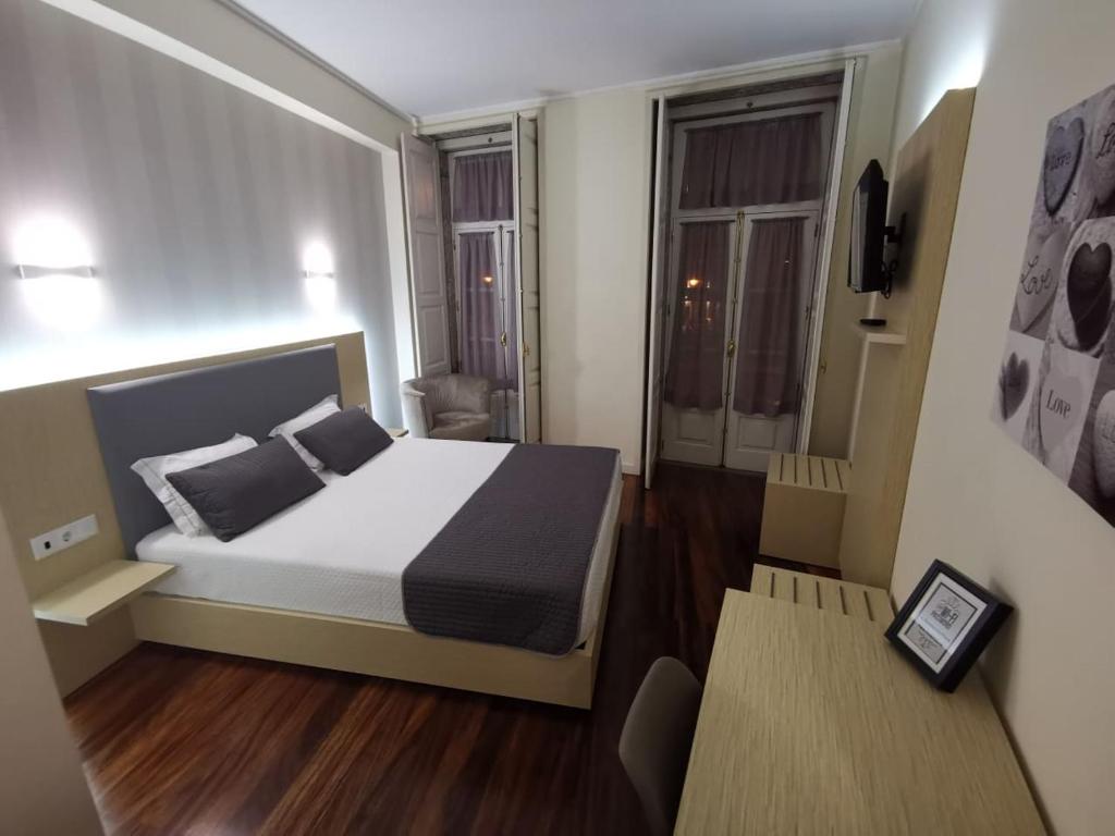 a small bedroom with a bed and a table at Hotel Residencial Dora in Braga