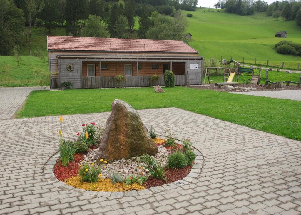 a rock in a flower bed in front of a building at Flößerdorf Großraming in Grossraming