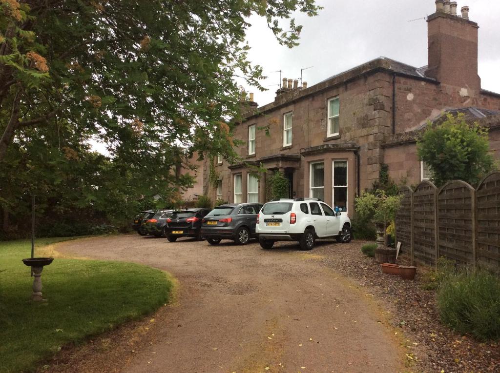 a house with cars parked in front of a driveway at Gramarcy House in Brechin