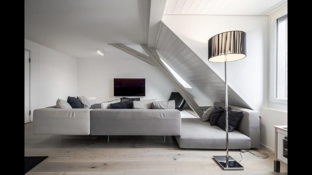 ein Wohnzimmer mit einem Sofa und einer Treppe in der Unterkunft Luxury Penthouse Apartment in Zürich