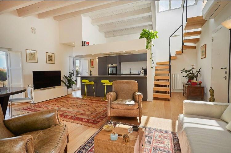 uma sala de estar com um sofá e cadeiras e uma cozinha em La Martorana, Luxury apartment with terrace em Palermo