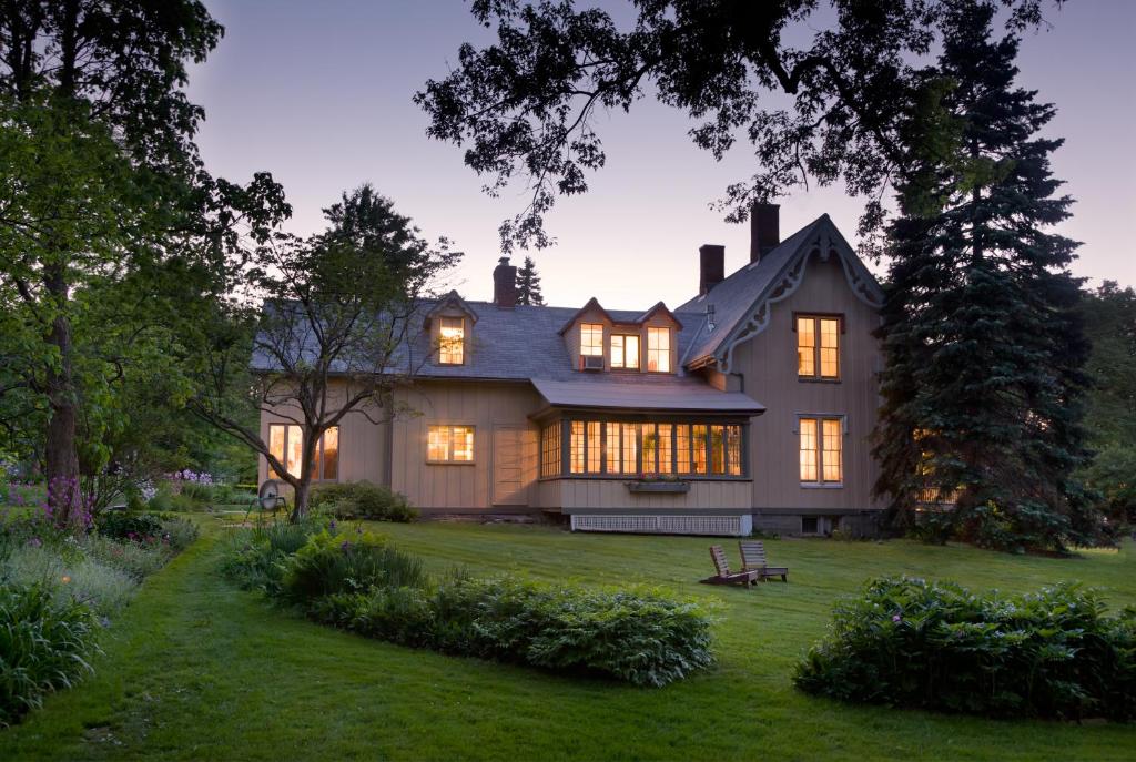 a large house with its lights on in the yard at Gothic Eves Inn and Spa Bed and Breakfast in Trumansburg