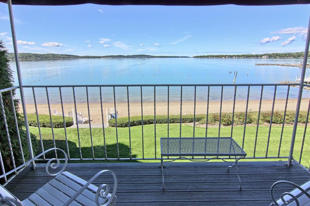 a balcony with a bench and a view of the beach at 212 Water Street Inn in Boyne City