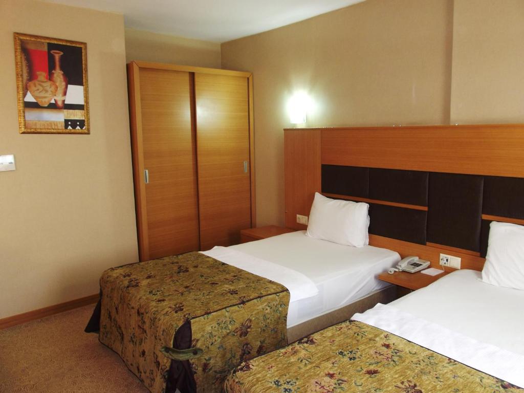 um quarto de hotel com duas camas e um telefone em Pınar Elite Hotel em Adana