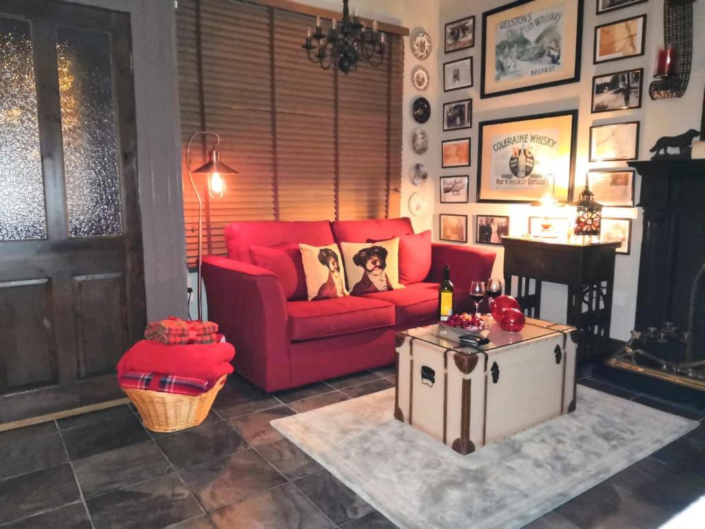 un soggiorno con divano rosso e tavolo di Herlihy's, Half-Way-House a Farranfore