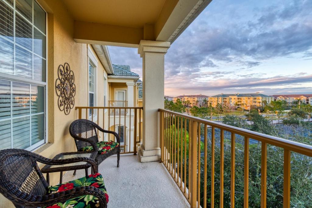Un balcón con 2 sillas y vistas. en Deluxe 3 Bedroom Apartment 404 en Orlando