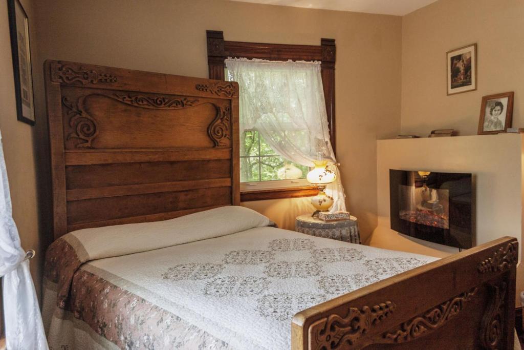 a bedroom with a bed and a fireplace and a window at Prairie Creek Inn in Walton