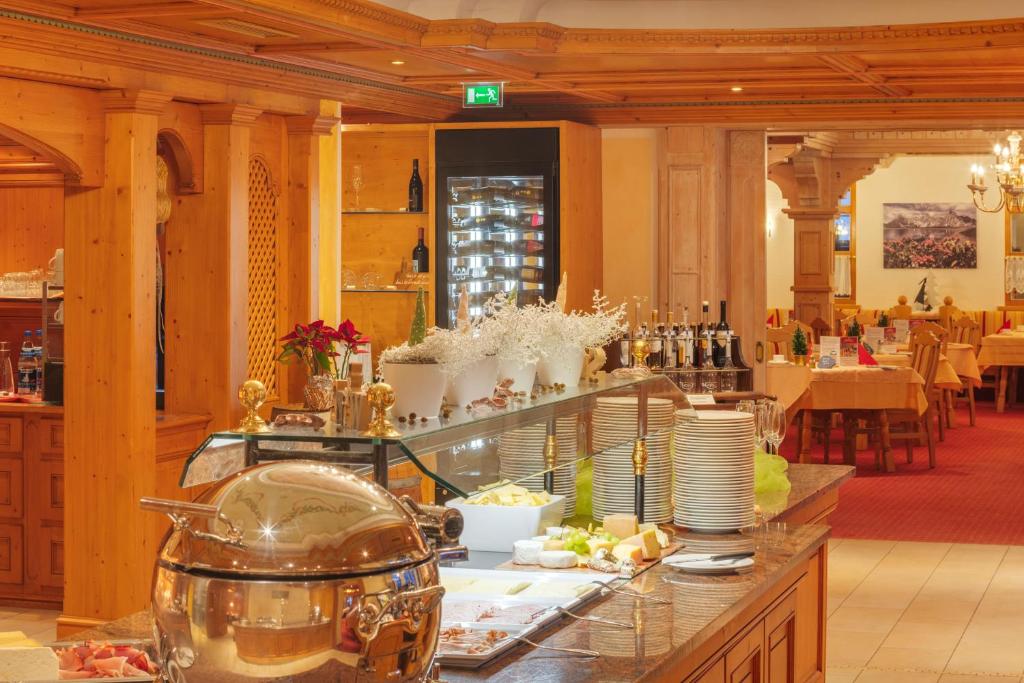 a restaurant with a counter with food on it at Berg-Spa & Hotel Zamangspitze in Sankt Gallenkirch