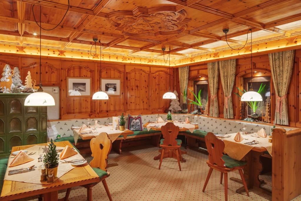 a restaurant with wooden walls and tables and chairs at Berg-Spa & Hotel Zamangspitze in Sankt Gallenkirch