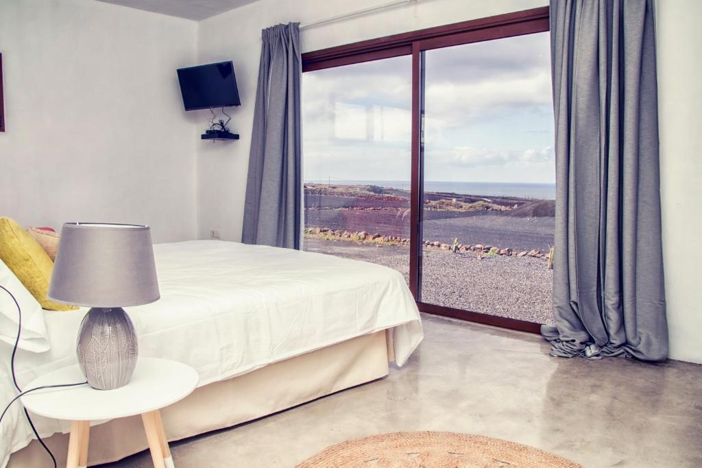 a bedroom with a bed and a window with a view at Casa De La Nobleza in Tinajo