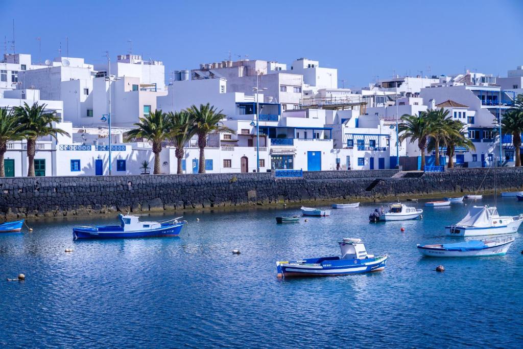 a group of boats in a body of water with buildings at Rooms & Suites Loft 2G Deluxe Edition Arrecife in Arrecife