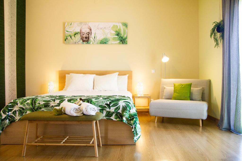 um quarto com uma cama e uma mesa com uma cadeira em Villa Prana Guesthouse, Yoga & Ayurveda em Portimão