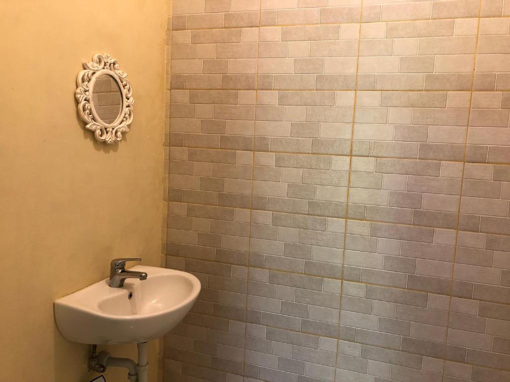 Un baño con un lavabo y un espejo en la pared. en Guest house KupuKupu39, en Kuta