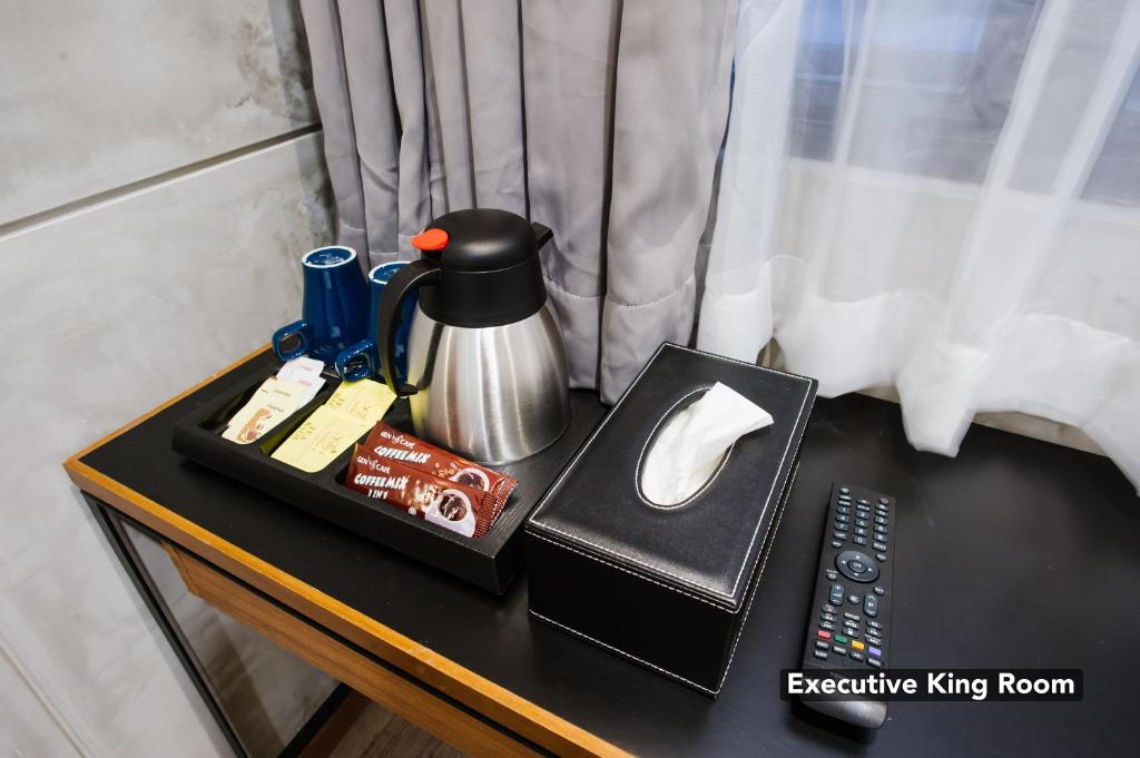 An in-room beverage station beside the window, with tea supplies and a television remote.