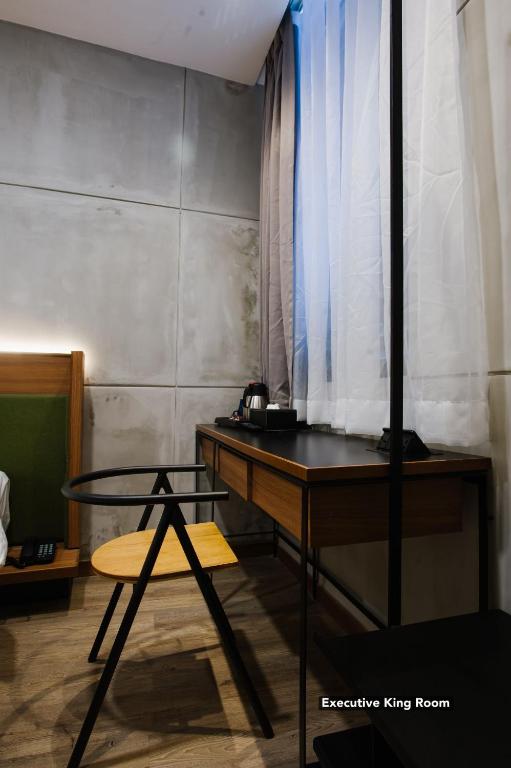 A compact desk and chair beside the curtained window in an Executive King Room.