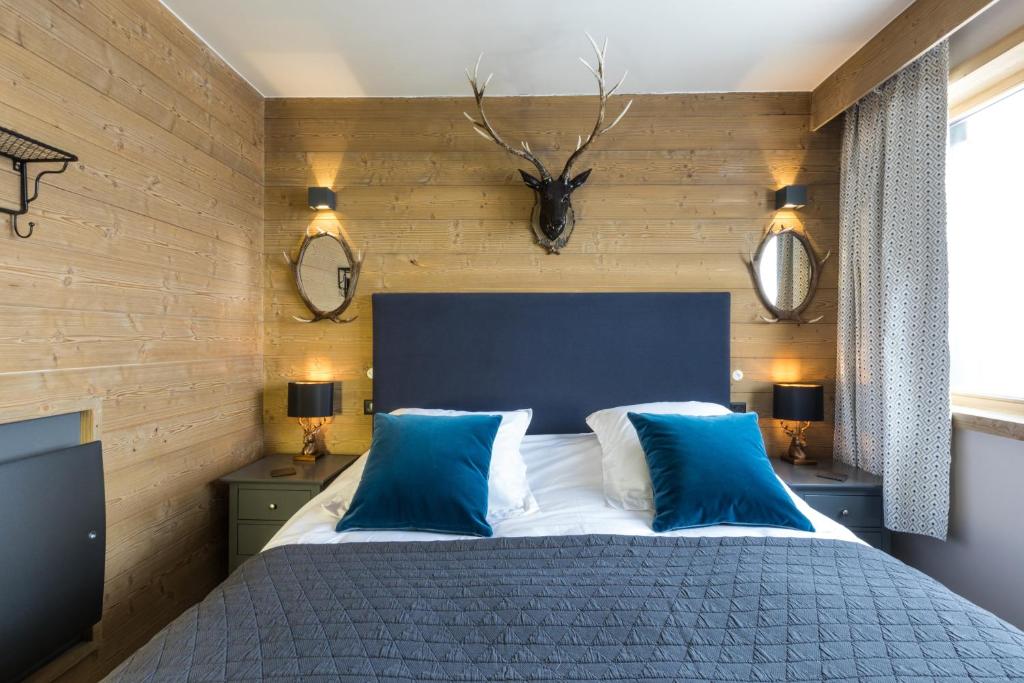 a bedroom with a large bed with blue pillows at Phoenix 101 in Tignes