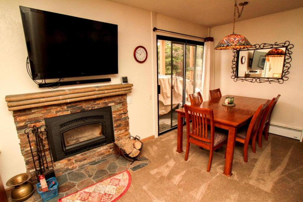 a living room with a fireplace and a table and a television at Discovery 4 #115 in Mammoth Lakes
