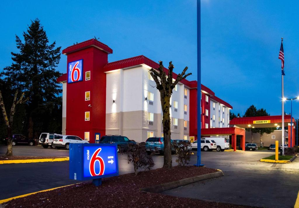 ein großes rotweißes Gebäude mit einem Parkplatz in der Unterkunft Motel 6-Wilsonville, OR - Portland in Wilsonville