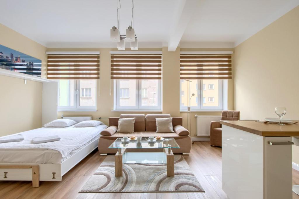 una camera da letto con un letto, un divano e un tavolo di Studio Tamka by BookingHost a Varsavia