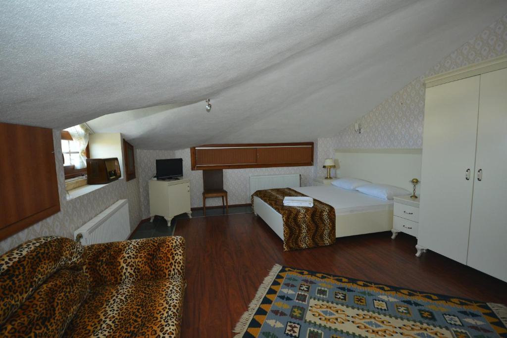 Habitación de hotel con cama y sofá en Hotel Casa Villa, en Eceabat