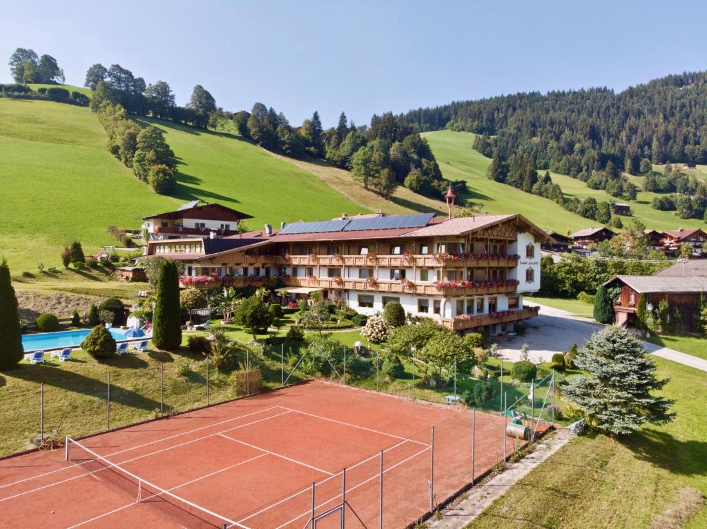 a tennis court in front of a building at Hotel Lenzenhof in Oberau