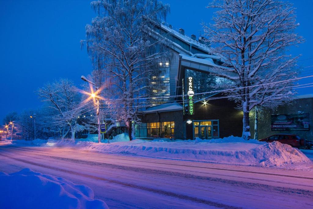 a snowy street at night with a building at Hotel K-Vizit Toksovo in Toksovo