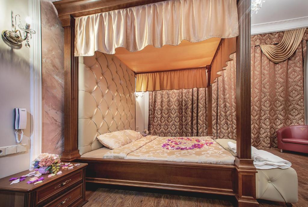 a bedroom with a canopy bed with flowers on it at Alex Hotel on Vasilyevsky Island in Saint Petersburg