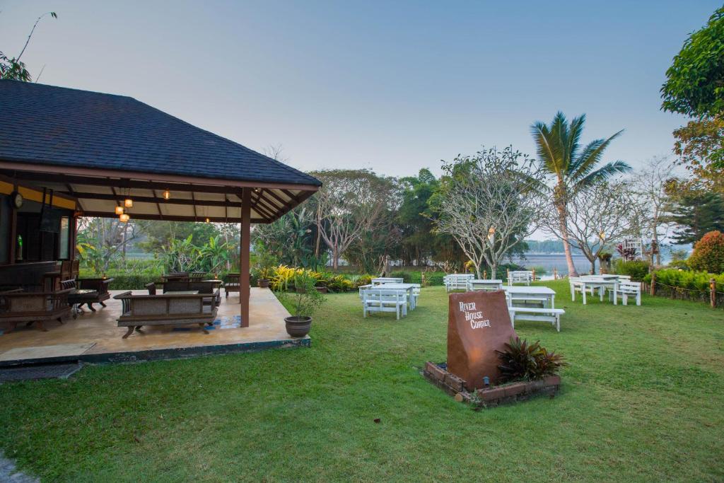un cenador con mesas y sillas en un parque en The Imperial River House Resort, Chiang Rai, en Chiang Rai