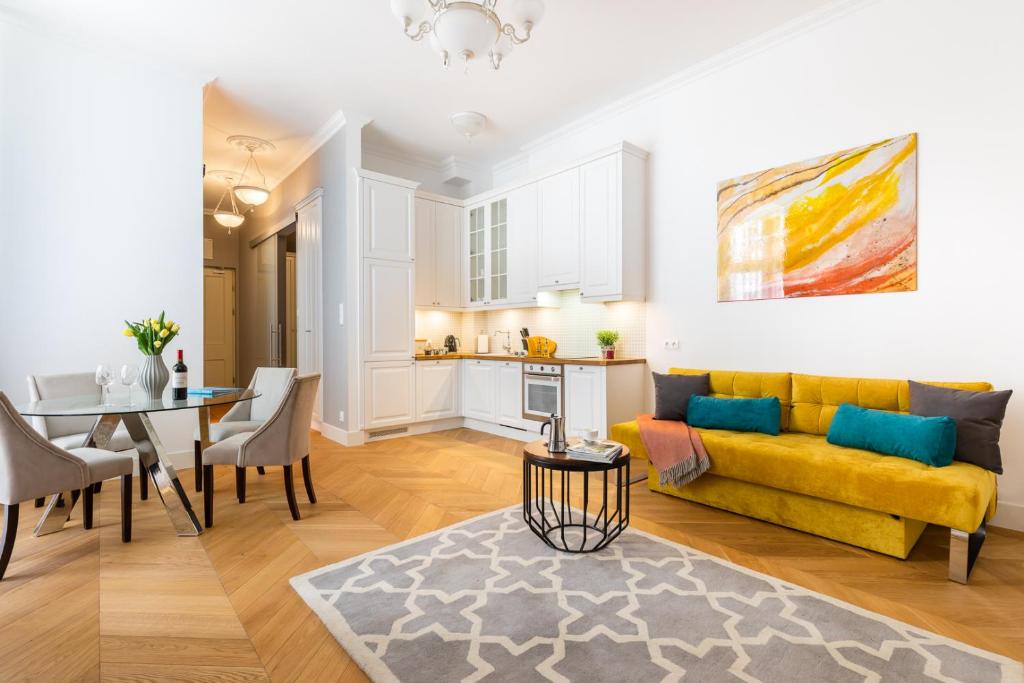 ein Wohnzimmer mit einem gelben Sofa und einem Tisch in der Unterkunft Rent like home - Noakowskiego 16 in Warschau