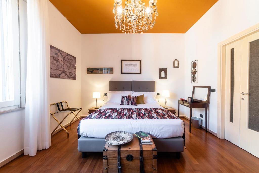 
a bedroom with a bed, a chair, and a lamp at Bibliò Rooms Guesthouse in Bologna

