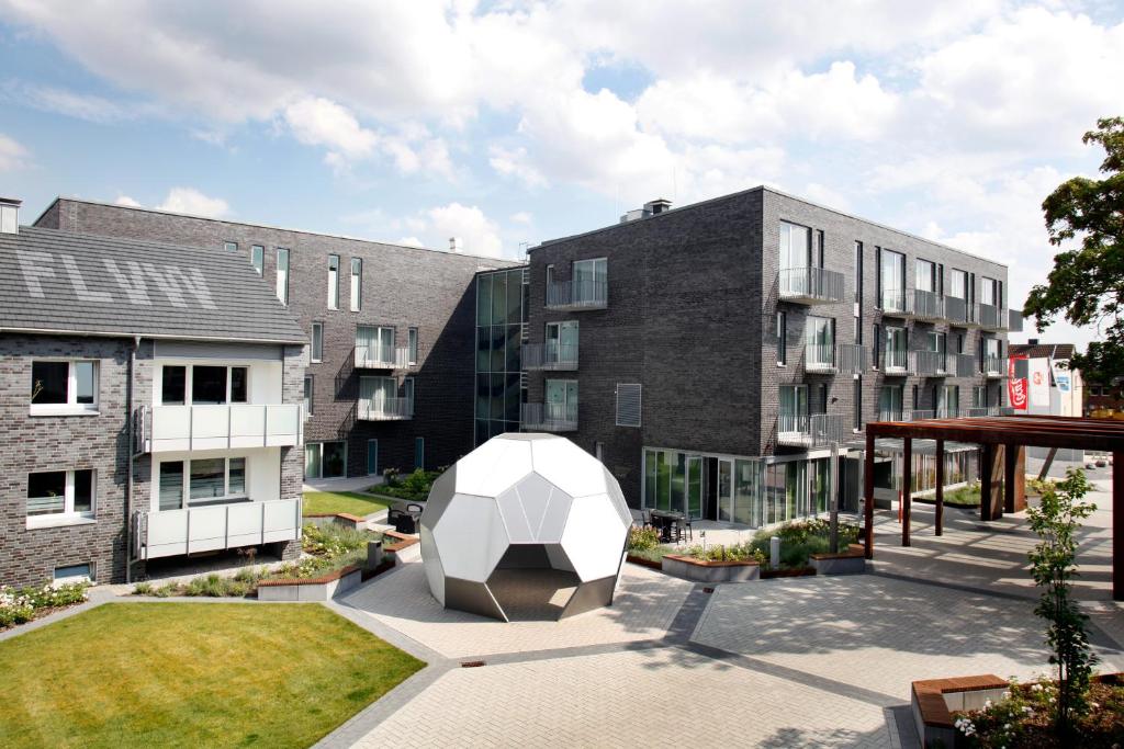 un patio con una escultura frente a un edificio en SportHotel Kaiserau, en Kamen