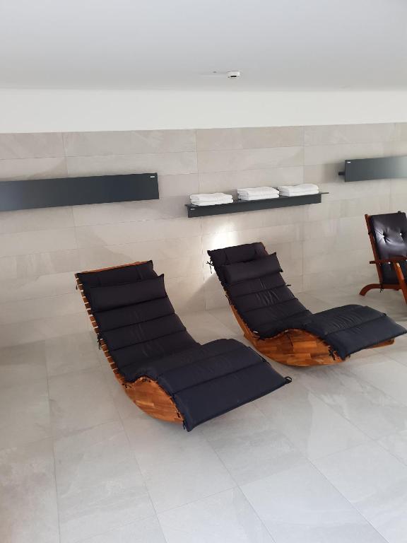 two chairs with black cushions in a room at Hotel & Restaurant Forni in Airolo