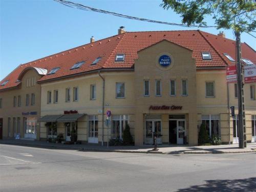 un gran edificio en la esquina de una calle en Panzió Sissi, en Gödöllő
