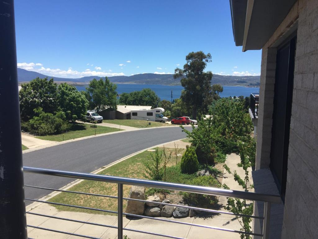 a balcony with a view of a road and a lake at Lake Vista in Jindabyne