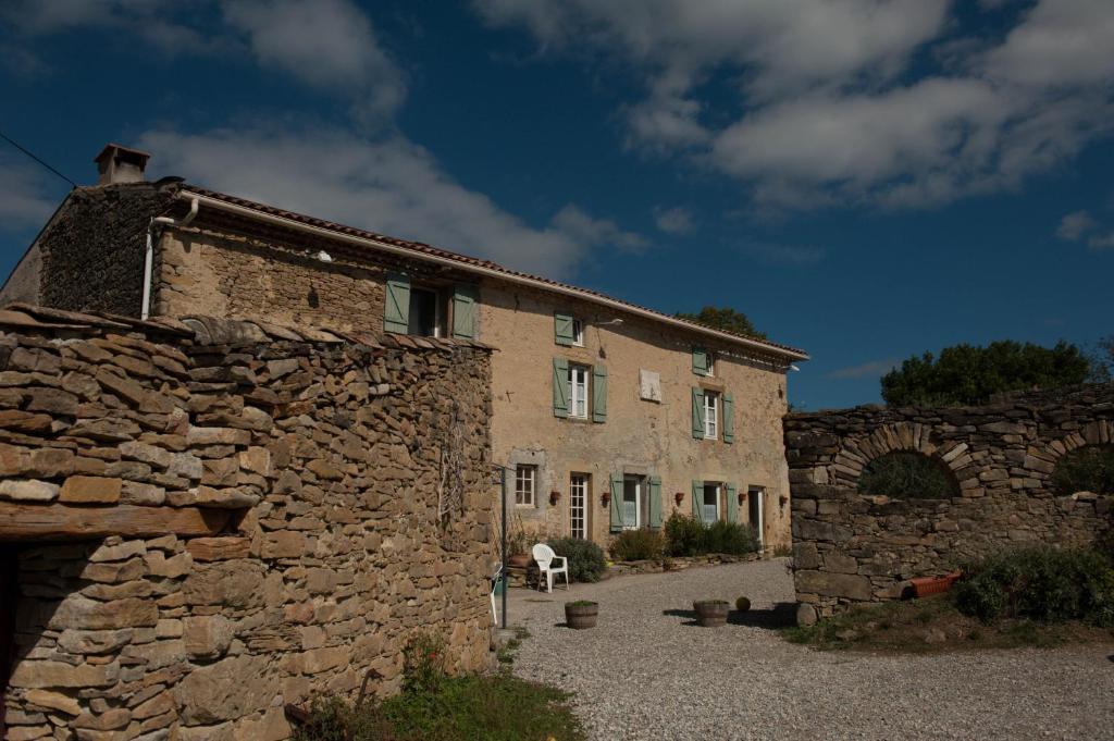 un viejo edificio de piedra con un caballo blanco delante de él en Domaine Bellelauze, en Bouriège