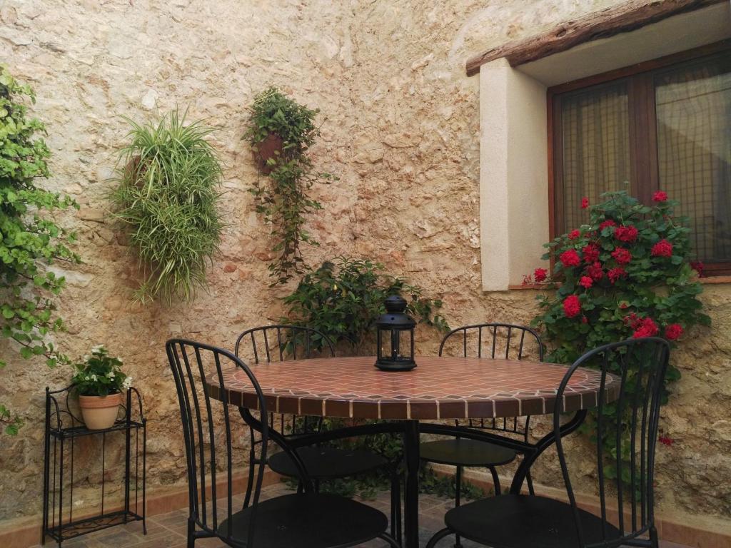 una mesa y sillas frente a un edificio con flores en Casa Llebra I, en Tortosa