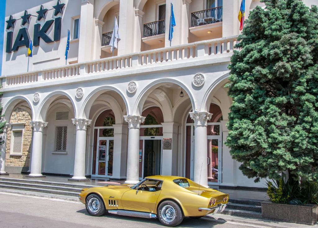 a yellow car is parked in front of a building at Iaki Conference & Spa Hotel in Mamaia