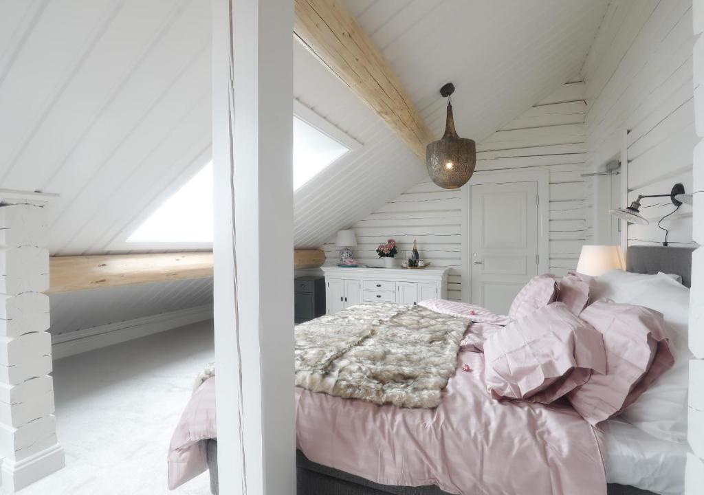 ein Schlafzimmer mit einem rosa Bett im Dachgeschoss in der Unterkunft Sara´s Bed and Breakfast in Erikslund