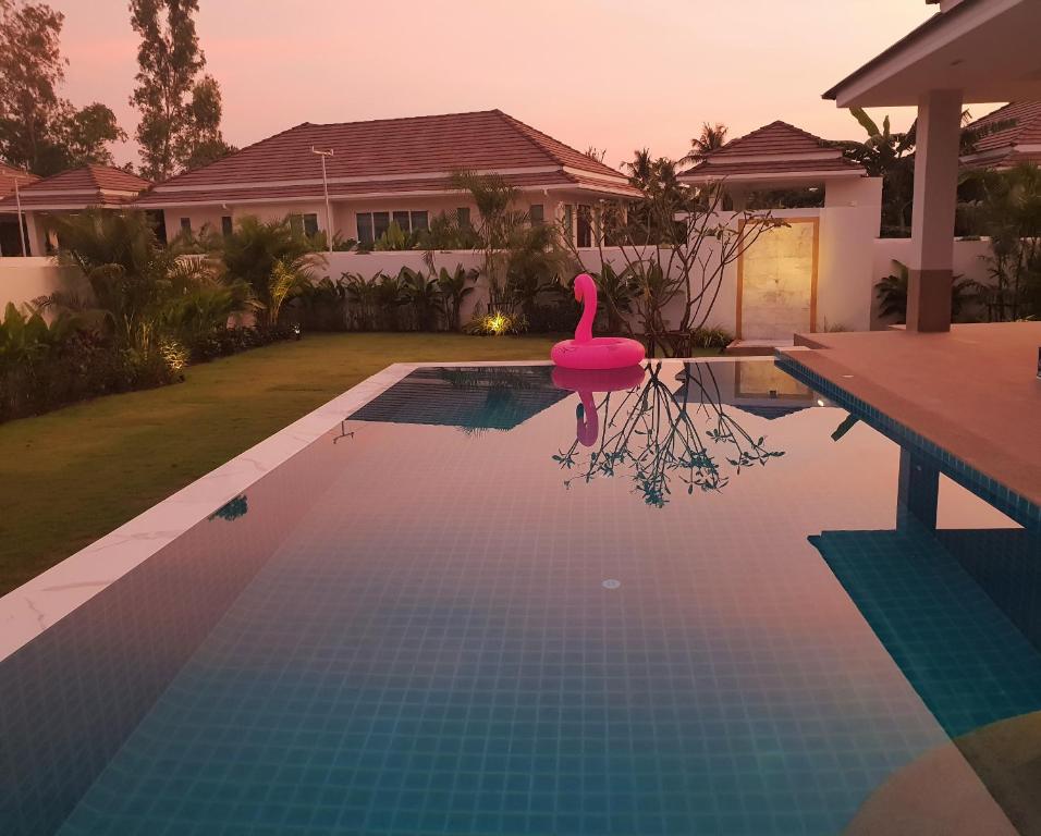 una piscina con un cisne rosa frente a una casa en Villa de Veluwe @ Hua Hin en Hua Hin